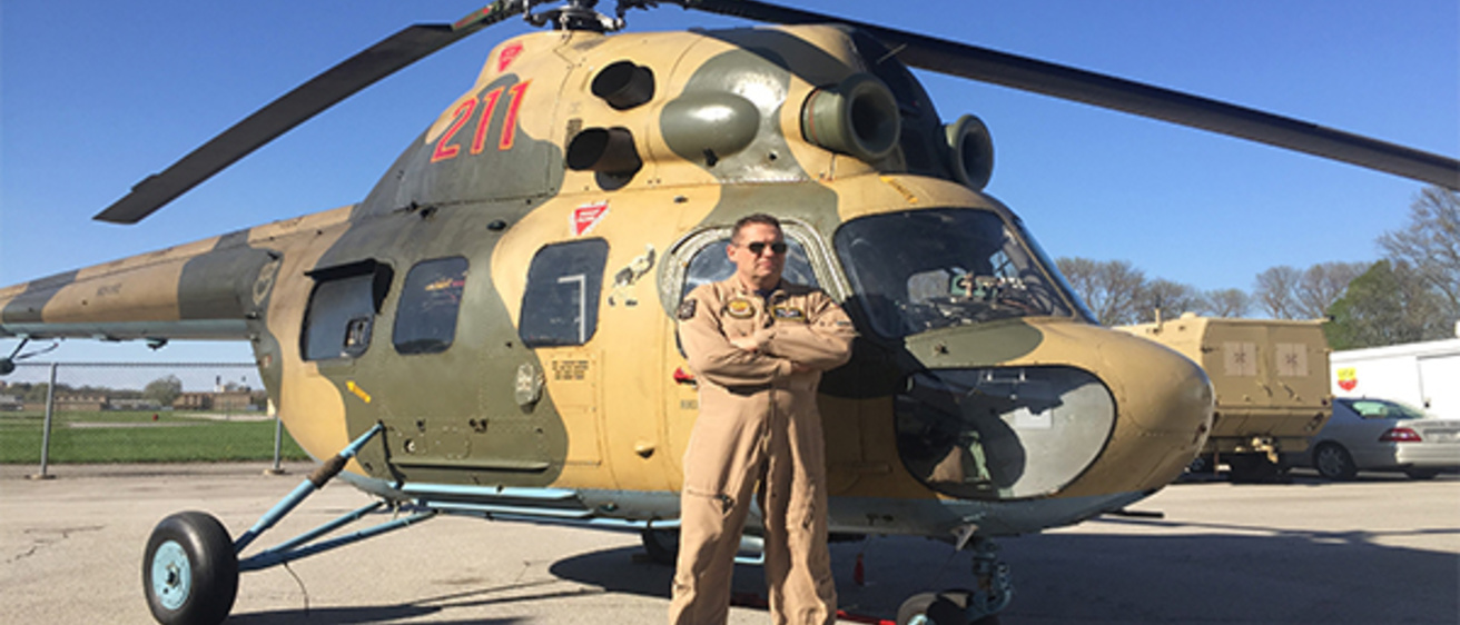 Tom Schnell standing in front of a helicopter