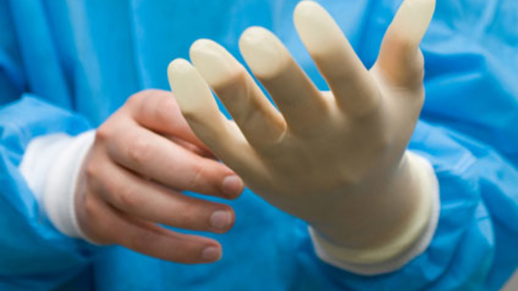 Close up of a person's hands putting on a latex glove